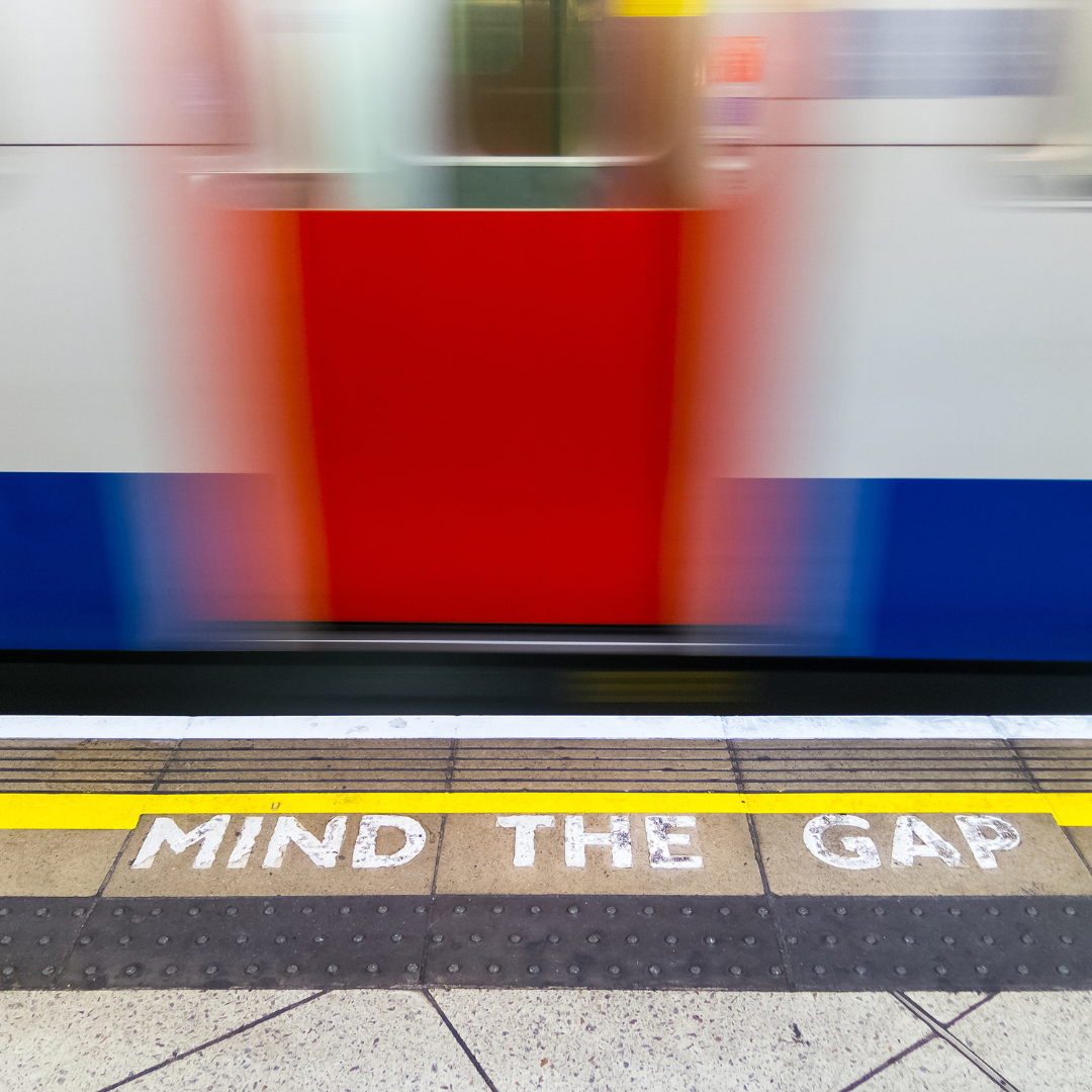 Mind The Gap written on floor with red tram door